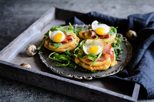 istock Savoury yoghurt and scallion pancakes with Black Forrest ham, smoked cheese, quail egg and arugula 942451696