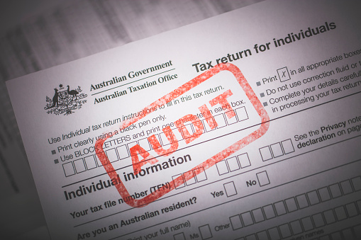 An editorial stock photo of the Australian Government Taxation forms with a red AUDIT ink stamp to illustrate Tax Audits or other Tax related themes.