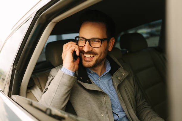 istock Businessman using mobile phone in the car 942451988