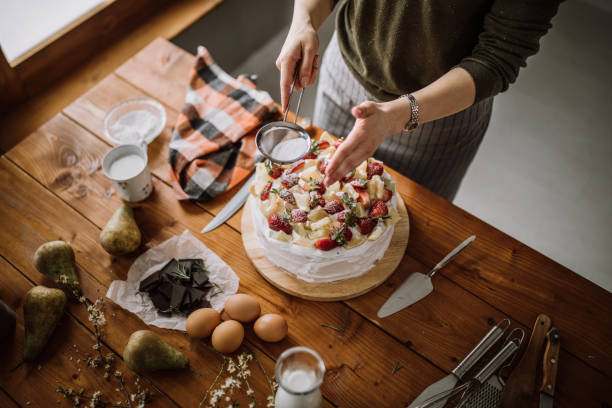istock Woman Decorating Cake With Lemon, Lime And Strawberries 942452130