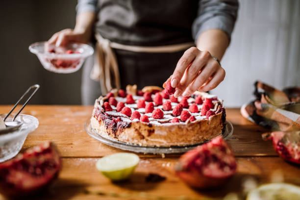 세련 된 블랙베리 파이에 라스베리를 추가 - baking cake making women 뉴스 사진 이미지