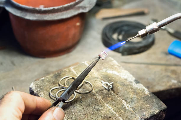 istock Jeweler using a gas - oxygen welding torch on a silver piece. 942456508