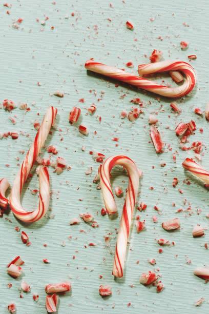 istock Xmas Candy cane and broken crushed pieces on greenish background with copy space 942459056