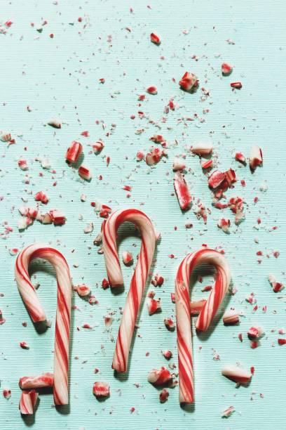 Xmas Candy cane and broken crushed pieces on greenish background with copy space