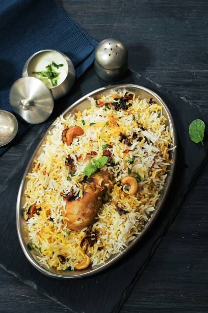 istock Hyderabadi chicken Dum biryani served with yogurt dip, top view 942460308