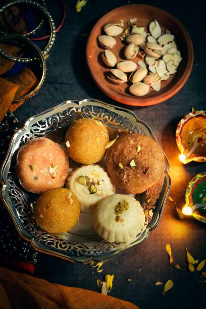 istock Colorful Clay  Diya lamps lit with sweets on side - Happy Diwali, selective focus 942463522