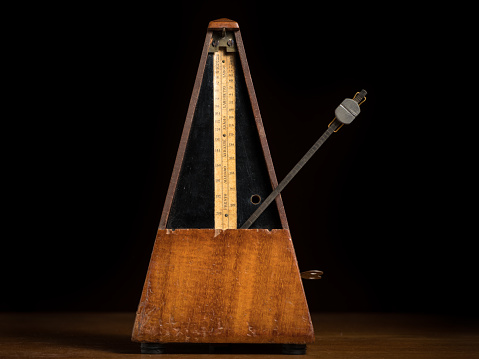 Detail of an old mechanic musical metronome, scale showing the various tempos, pendulum right
