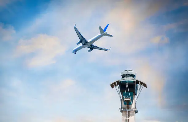 Airplane flying over air traffic control tower. LAX, California