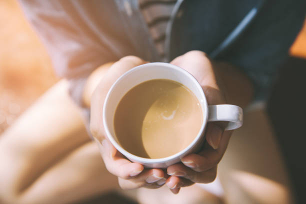 istock hands holding hot cup of coffee or tea in morning sunlight 942491666