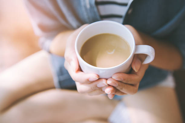 istock hands holding hot cup of coffee or tea in morning sunlight 942491678