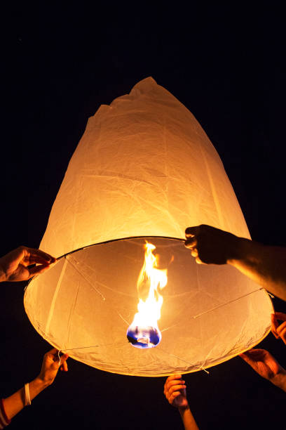 istock Hands releasing Yee-Peng flying paper lantern, Thailand. 942502354