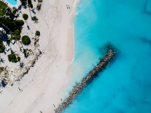 Drone photo of pier in beach in Grace Bay, Providenciales, Turks and Caicos Drone photo of beach with red umbrellas in Grace Bay, Providenciales, Turks and Caicos. grace bay stock pictures, royalty-free photos & images