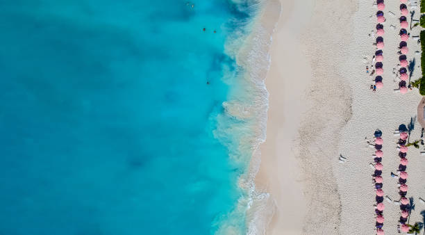 drohne panorama des strandes mit roten sonnenschirmen im grace bay, providenciales, turks- und caicosinseln - providenciales stock-fotos und bilder