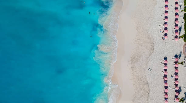 Drone panorama of beach with red umbrellas in Grace Bay, Providenciales, Turks and Caicos Drone panorama of beach with red umbrellas in Grace Bay, Providenciales, Turks and Caicos. providenciales stock pictures, royalty-free photos & images