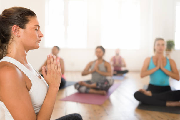 istock Female teaching yoga with hands clasped at studio 942510090