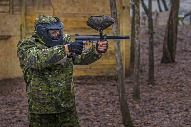 istock Paintball player takes aim, hides and shooting. Man wearing protective equipment 942510414