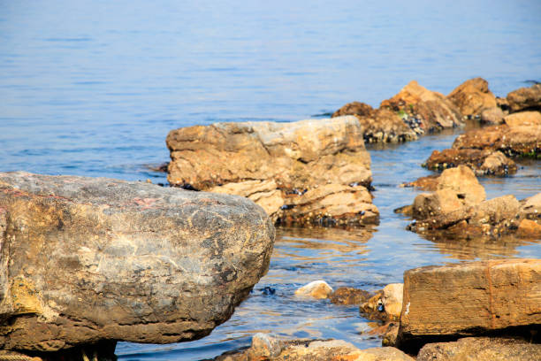 istock rock stone in blue sea 942510738