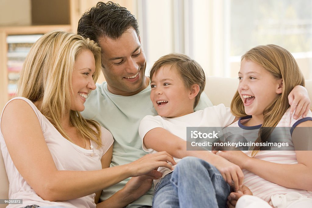 Family sitting in living room smiling  30-39 Years Stock Photo