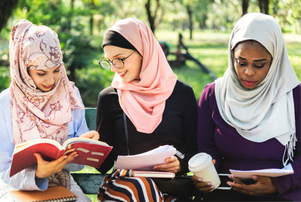 istock Friends reading book together at park 942515864