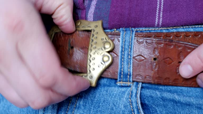 unfastening the belt on trousers, decorative buckle