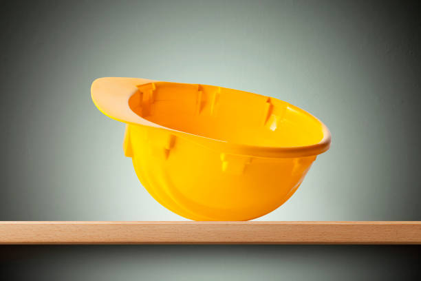 Yellow safety helmet upside-down on the shelf.