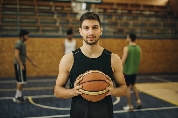 istock Young basketball player with a ball on playing field. 942523380