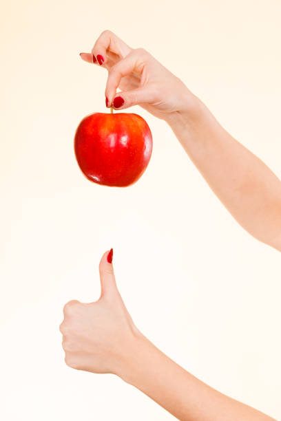 istock Woman hand holding delicious red apple 942523446