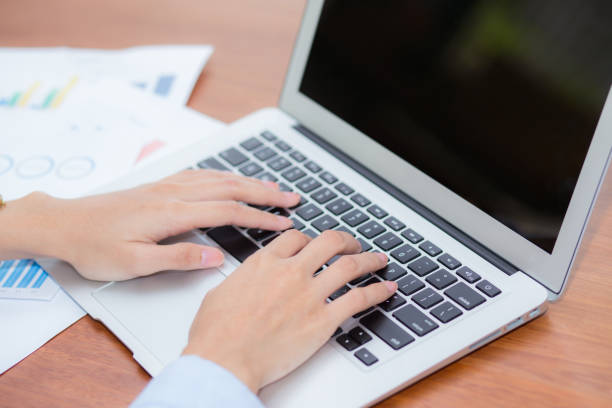 istock Closeup work with finance analysis and planing data on laptop, typing and paper graph with computer statistic for success, top view, business freelance concept. 942525814