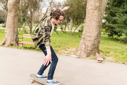 Teenage skater with glasses keeping the balance. Skaters at the public park in Varna, Bulgaria.