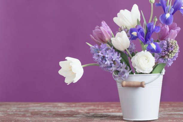 istock spring flowers in bucket on pink background 942530584