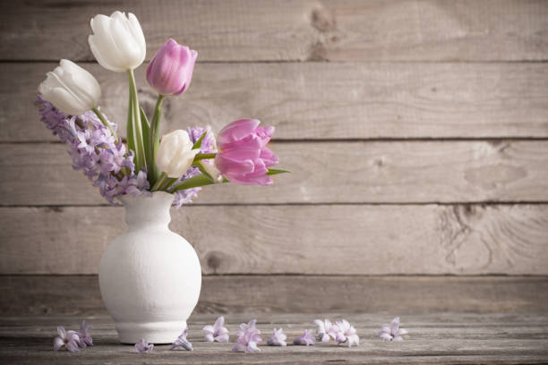 istock spring flowers in vase on old wooden background 942530592