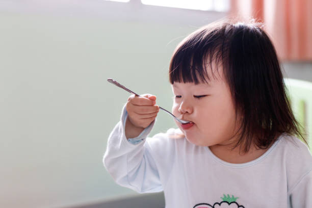 istock Little girl child eating breakfast. 942530872