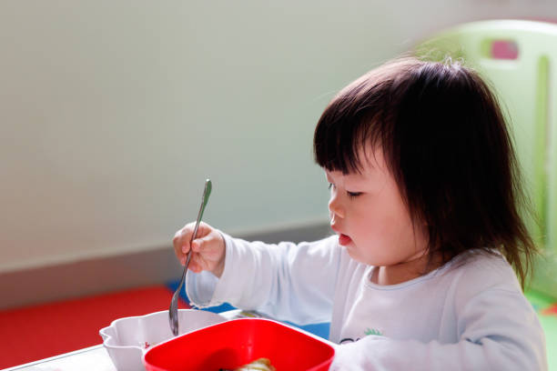 istock Little girl child eating breakfast. 942530874