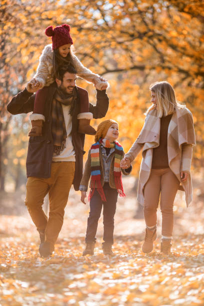 istock Happy family having fun while walking in autumn park. 942531016