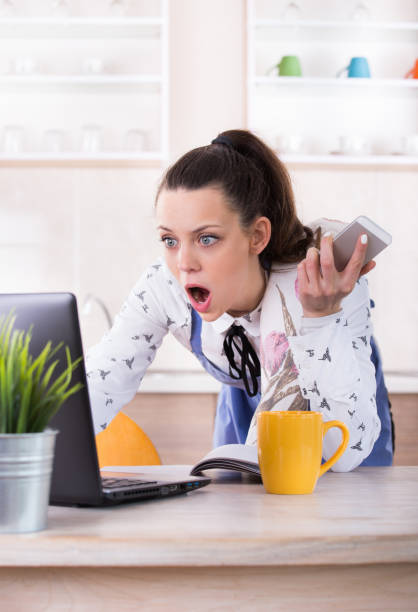 istock Stressed woman cooking and working at laptop in kitchen 942534514