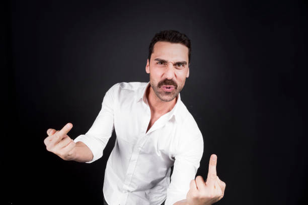 istock Young handsome man showing fuck off hand gesture 942538658