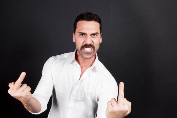 istock Young handsome man showing fuck off hand gesture 942538668