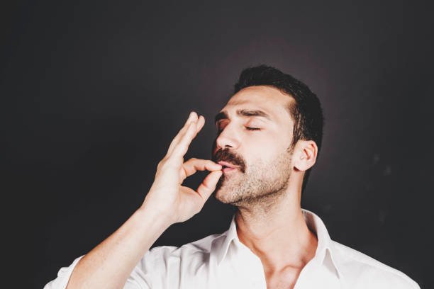 Young handsome man with beard and mustache studio portrait Young handsome man with beard and mustache kissing fingers, hand gesture for perfection Ready To Eat stock pictures, royalty-free photos & images