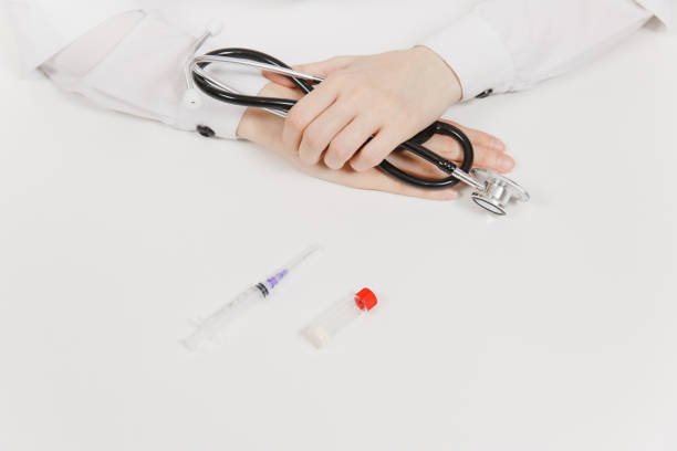 Doctor at white desk with syringe with needle, bottle with medicine in light office in hospital. Woman holds in hands stethoscope. Medicine concept. Copy space. With place for text. Advertising area. Doctor at white desk with syringe with needle, bottle with medicine in light office in hospital. Woman holds in hands stethoscope. Medicine concept. Copy space. With place for text. Advertising area niñas stock pictures, royalty-free photos & images