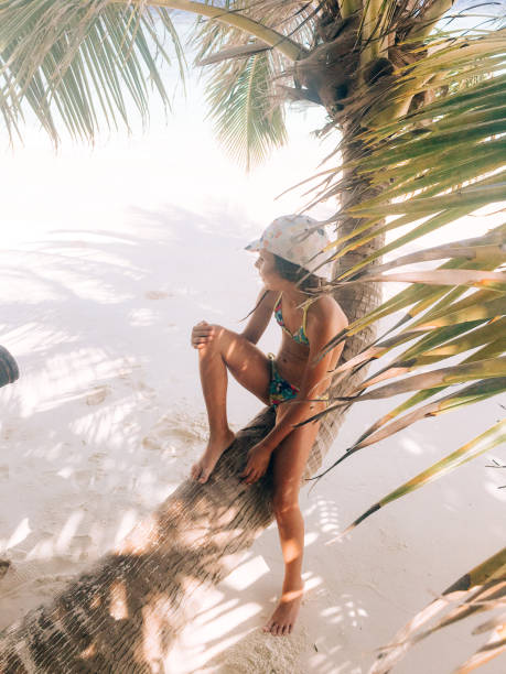 istock Young Girl Sitting on Palm Tree on Tropical Island 942540744