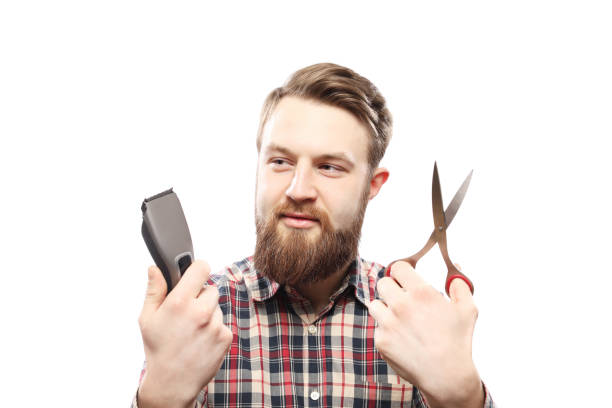 istock Bearded man between hair clipper and scissors 942541524