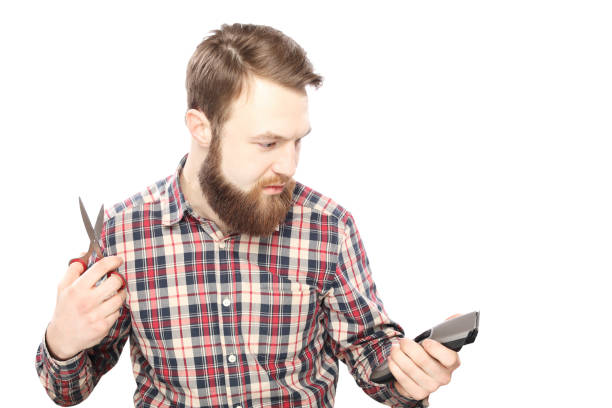 istock Bearded man between hair clipper and scissors 942541570