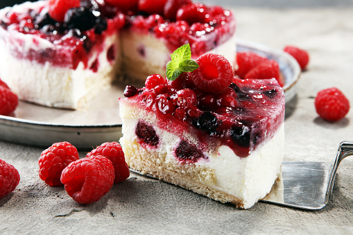 raspberry cake and many fresh raspberries. fresh spring cream cake with blackberries, blueberries and raspberries
