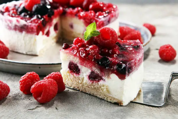 raspberry cake and many fresh raspberries. fresh spring cream cake with blackberries, blueberries and raspberries