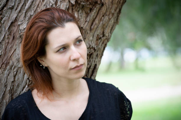 Young sad woman takes a break in the park