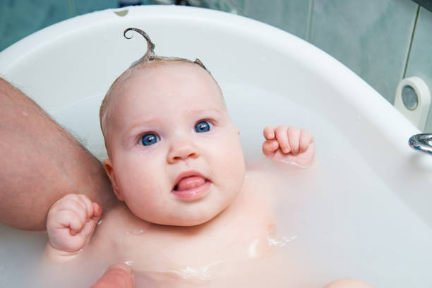 istock Bathing funny baby in the tub. 942552612