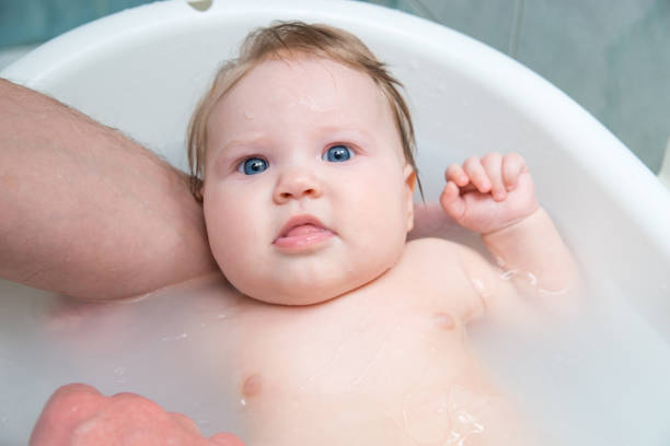 istock Bathing funny baby in the tub. 942552616