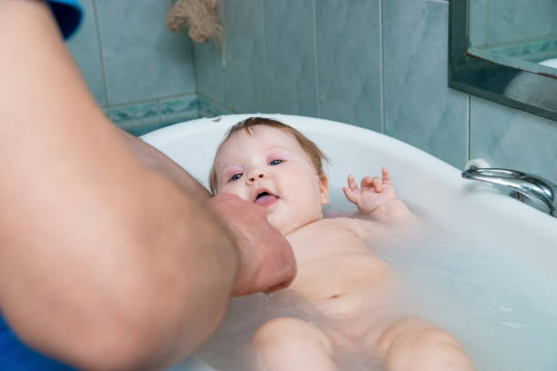 istock Bathing funny baby in the tub. 942552638