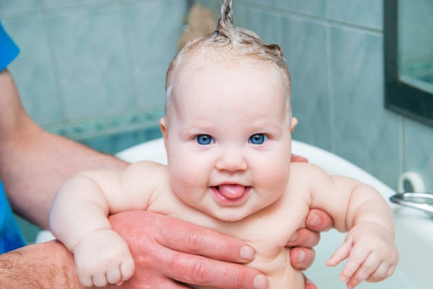 istock Bathing funny baby in the tub. 942552648
