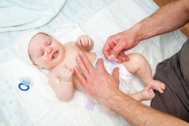 istock Dad puts a diaper on the baby. 942552722
